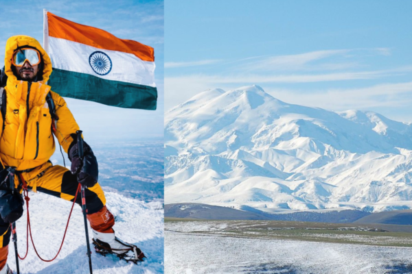 Rohtash Khileri standing on the summit of Mount Elbrus, clouds below, snow around him